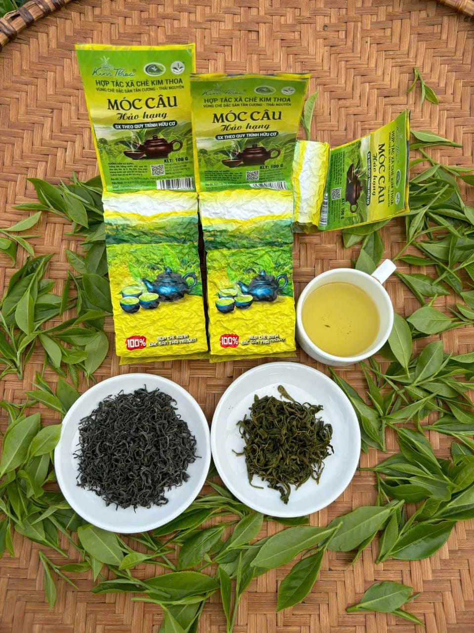 Hai gói Trà Móc Câu Hảo Hạng cùng chén nước trà vàng xanh